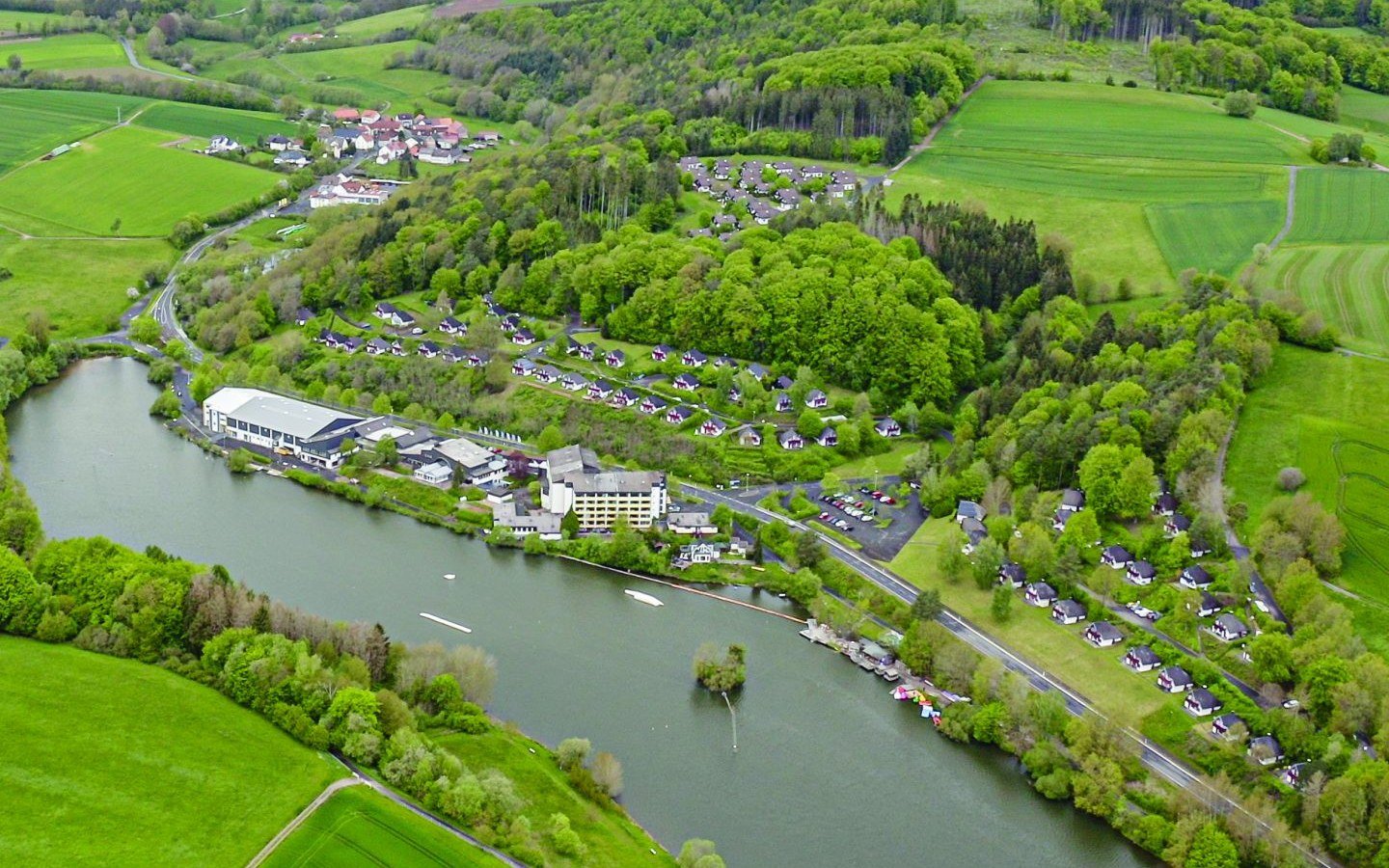 Luftaufnahme des Sri Vitthal Dham in Kirchheim mit See und angrenzenden Gebäuden